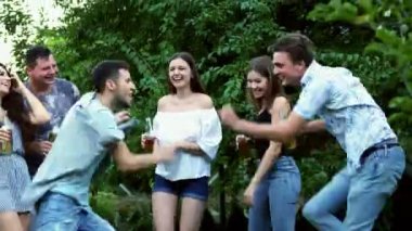 İki adam Dans savaş, arkadaşlar clink şişe, içki bira, yaz akşamı partide