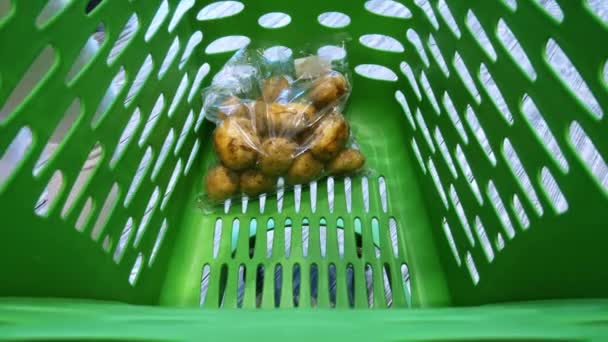 Close-up van supermarkt trolley, vrouw zet groenten en fruit aan mand — Stockvideo