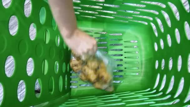 Kadın elinin yakın çekim süpermarket arabası sebze ve meyve koyar — Stok video