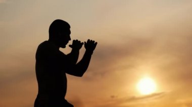 Bir günbatımı gökyüzü, mücadele ve spor arka planda bir kas atletik adam boks silueti