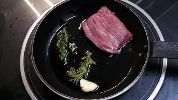 Grand steak est frit dans une poêle dans la cuisine du restaurant en gros plan — Video