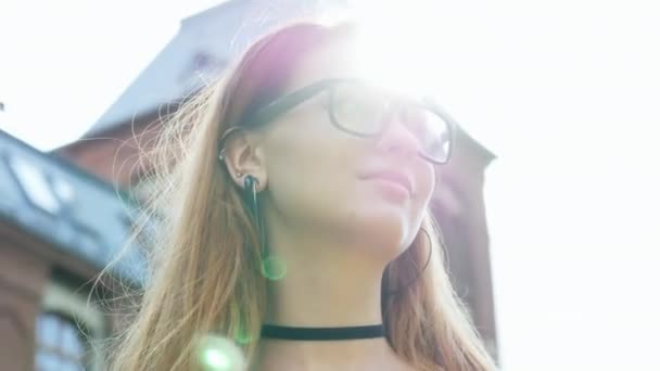 Close-up retrato de menina bonita, estudante ou freelancer, mulher de óculos olha em volta, raios de sol brilhar — Vídeo de Stock