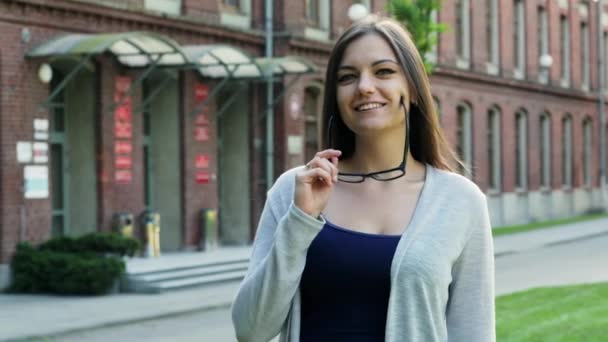 Retrato de cerca de chica, estudiante o freelancer, mujer se pone gafas y mira la cámara — Vídeos de Stock