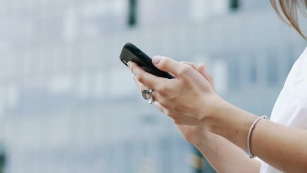 Primo piano delle mani di una donna d'affari in possesso di un telefono cellulare moderno, messaggi di sms donna, chat con gli amici, navigazione in Internet — Video Stock