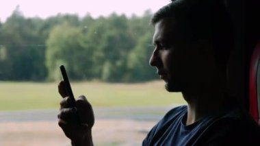 Yalnız erkek yakın çekim siluet otobüs yolculuğu seyahat, cep telefonu kullanın