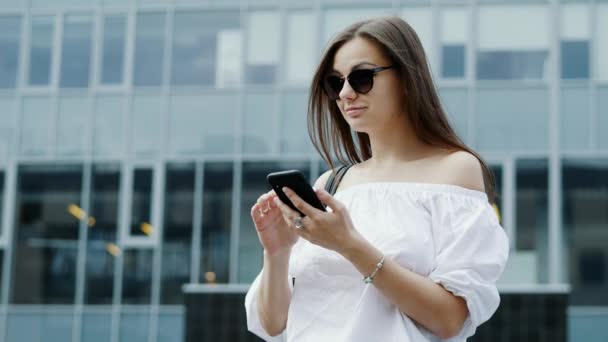 Nowoczesna młoda kobieta interesu trzyma telefon komórkowy, Kobieta wiadomości tekstylny, rozmawiając z kolegami, przeglądanie Internetu — Wideo stockowe