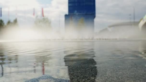 Водний фонтан у діловому районі центру міста, бризки, хвилі та краплі — стокове відео