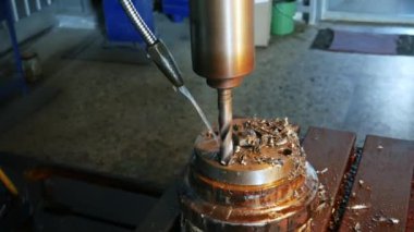 Torna tezgahındaki metal parçalarında sondaj işlemi, matkabın üzerine su dökülüyor,