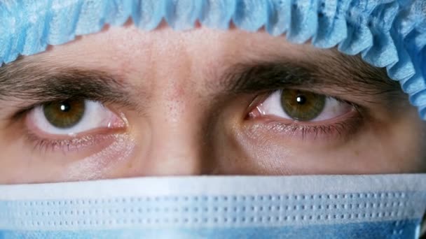 Ojos cercanos de un médico varón cansado, se quita la máscara, durante la cirugía — Vídeos de Stock