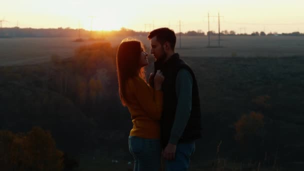 Silhueta de casal adorável olham um para o outro olhos antes de um beijo ao pôr-do-sol — Vídeo de Stock