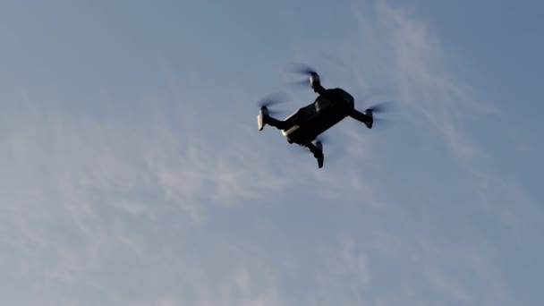 Quadcopter létá na modré obloze, dron natáčí video — Stock video