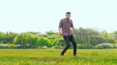 Yeşil tarlada dans eden çılgın, başarılı adam.