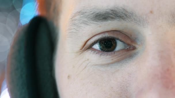 Close-up van het oog van de mens, in de leerling de reflectie van bloemenslingers en nieuwjaarslichten. — Stockvideo