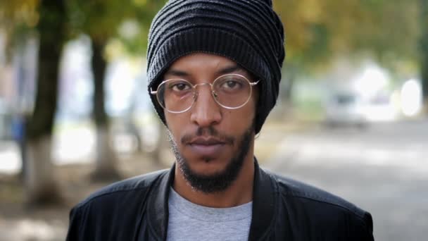 Miejski portret mieszanego człowieka rasy, stojącego na ulicy i patrzącego w kamerę w zwolnionym tempie — Wideo stockowe