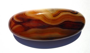 Akik mineral oval değerli taş. Parlak, katmanlı. Beyaz arka plan üzerinde izole