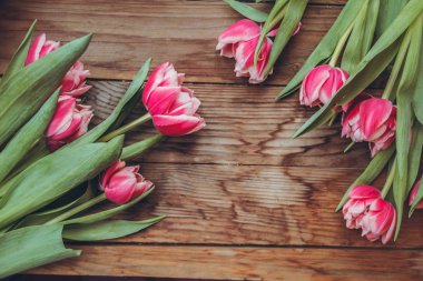 Laleler tahta bir masanın üzerinde yatıyor. Close. Ahududu çiçekleri. Pembe laleler. Tebrik kartları için arka plan.