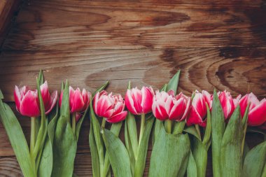 Laleler tahta bir masanın üzerinde yatıyor. Close. Ahududu çiçekleri. Pembe laleler.