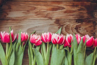 Laleler tahta bir masanın üzerinde yatıyor. Close. Ahududu çiçekleri. Pembe laleler.