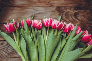 Laleler tahta bir masanın üzerinde yatıyor. Close. Ahududu çiçekleri. Pembe laleler.
