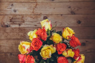 Tahta bir arka plan üzerinde gül buketi. Yukarıdan görüntüleyin. Sarı ve turuncu güller. Masada çiçek buketi.