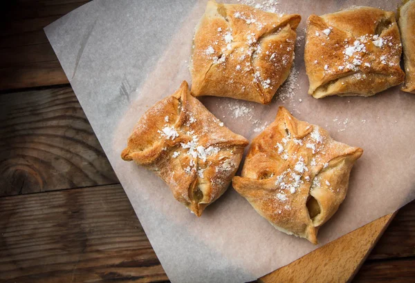 Apple buns. Fresh cakes. Fruit pies lie on a wooden table. — Stock Photo, Image