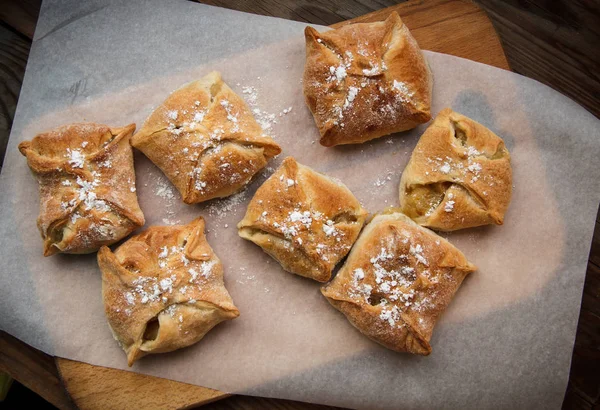 Apple buns. Fresh cakes. Fruit pies lie on a wooden table. — Stock Photo, Image