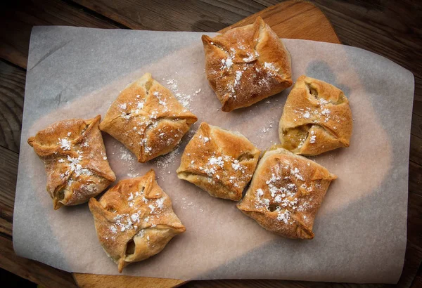 Apple buns. Fresh cakes. Fruit pies lie on a wooden table. — Stock Photo, Image