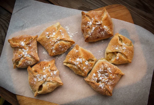 Pães de maçã. Bolos frescos. As tortas de fruto estão em uma mesa de madeira . — Fotografia de Stock