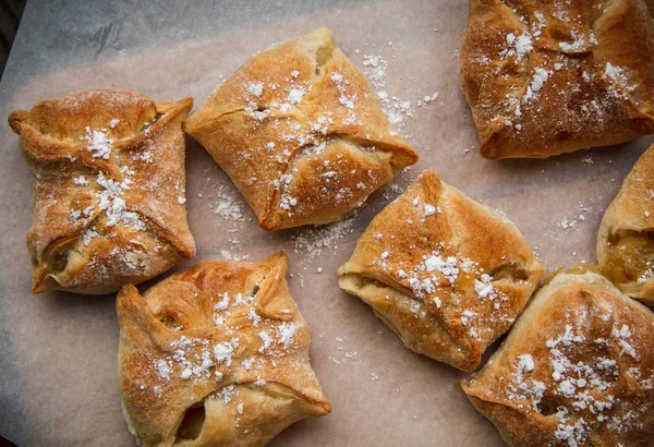 Apple buns. Fresh cakes. Fruit pies lie on a wooden table. — Stock Photo, Image