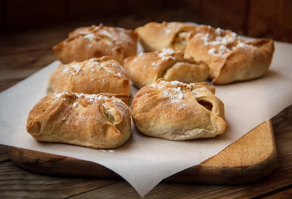 Bollos de manzana. Pasteles frescos. Pasteles de frutas se encuentran en una mesa de madera . — Foto de Stock