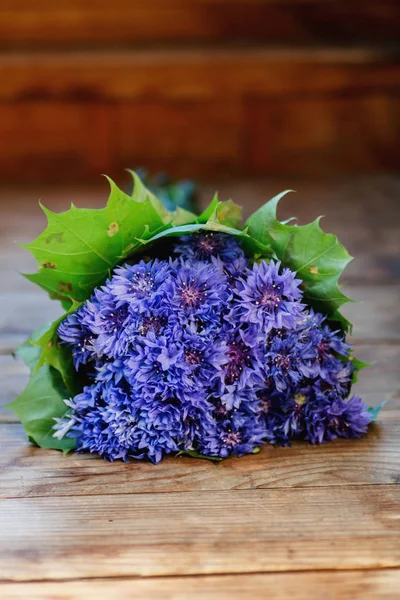 Cornkvětinová květina. Na dřevěném stole leží kytice modrých květů. Close-up. — Stock fotografie