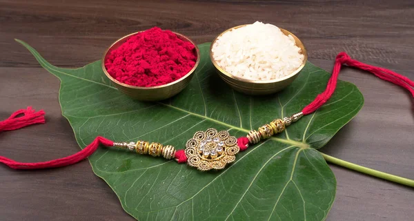 Raksha Bandhan festivali konsepti renkli arka planda ayrıntıları gösteren tasarımcı Rakhi veya bileklik bandını gösteriyor. Kardeşler ve Kız Kardeşler arasındaki aşkın sembolü. Seçici odak.