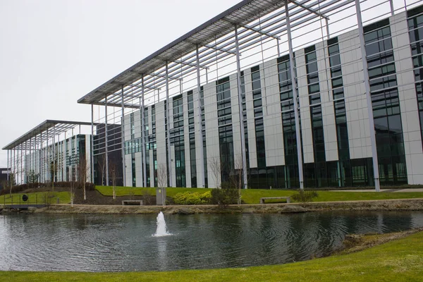 ユーロセントラルマキシムオフィス現代建築オフィスの正面にリラックス池と草がある建物外観をご覧ください — ストック写真