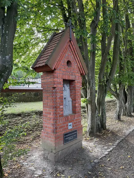 Yürüyüş yolunun yanında duran yaşlı ağaçların arasında bir şapel..