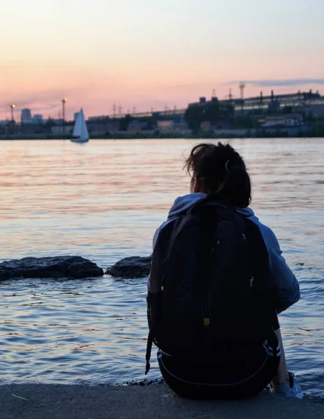 Göletin kıyısında oturan kadın.