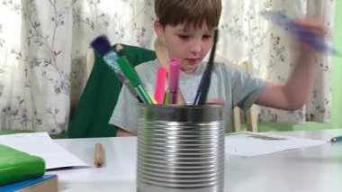 Evde kalemlerle resim çizen sevimli bir okul çocuğu. Yaratıcı bir işle uğraşıyor. Hobisine odaklanmış, evde boş vakit geçirirken hayal gücü ve sanatsal beceriler geliştiriyor.. 