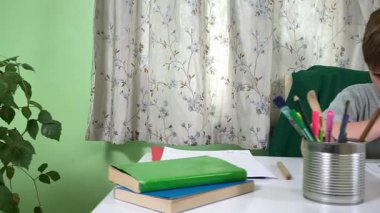 Evde kalemlerle resim çizen sevimli bir okul çocuğu. Yaratıcı bir işle uğraşıyor. Hobisine odaklanmış, evde boş vakit geçirirken hayal gücü ve sanatsal beceriler geliştiriyor.. 