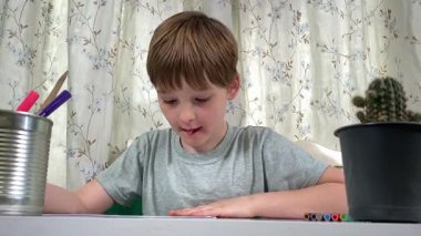 Evde kalemlerle resim çizen sevimli bir okul çocuğu. Yaratıcı bir işle uğraşıyor. Hobisine odaklanmış, evde boş vakit geçirirken hayal gücü ve sanatsal beceriler geliştiriyor.. 