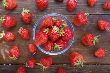 Ahşap bir zemin üzerine bir cam plaka olgun çilek