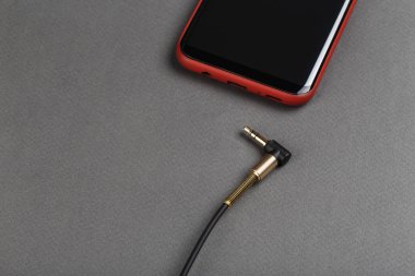 ses kablosu mini jack ve gri bir adam üstünde hareket eden telefon