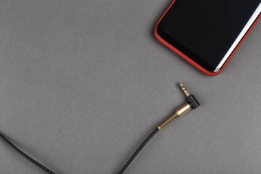 ses kablosu mini jack ve gri bir adam üstünde hareket eden telefon