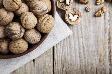 Tahta arka planda bir kasede ceviz.