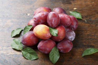 ahşap arka plan üzerinde yaprakları ile olgun erik