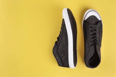 yeni siyah erkek spor ayakkabı. sarı bir arka plan, tex için alan üzerinde şık erkek ayakkabı