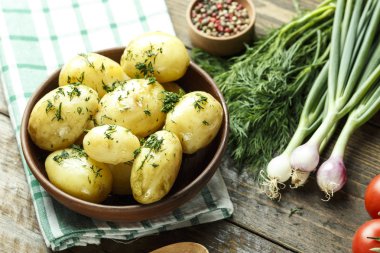 bir tabak içinde genç haşlanmış patates. yanında yeşil yatıyor. sağlıklı yaz lunc
