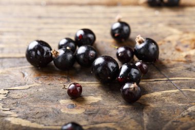 frenk üzümü olgun bir ürün bir ahşap arka plan üzerinde dağınık olduğunu. vitamini berry. tex için yer