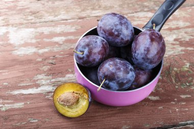 ahşap arka plan üzerinde bir tencerede olgunlaşmış erik. bir vitamin içeceği veya reçel erik ile hazırlanıyor