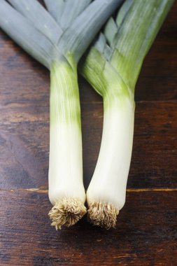 Genç sarımsak kahverengi ahşap bir masaya vuruyor. Sala üründe vitamini