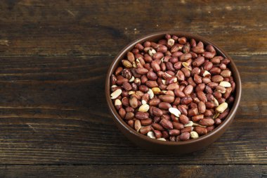 ahşap arka plan üzerinde bir kil tabak fıstık. tex için yer