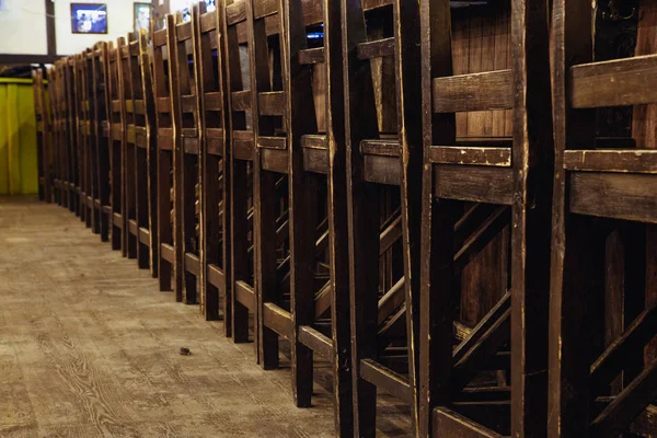 empty wooden chairs in the restaurant stand in a row along the bar counter